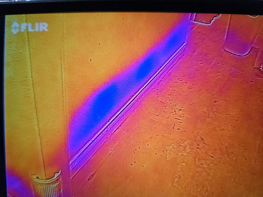 Thermal image showing a cold, wet patch inside a wall that looks dry to the eye